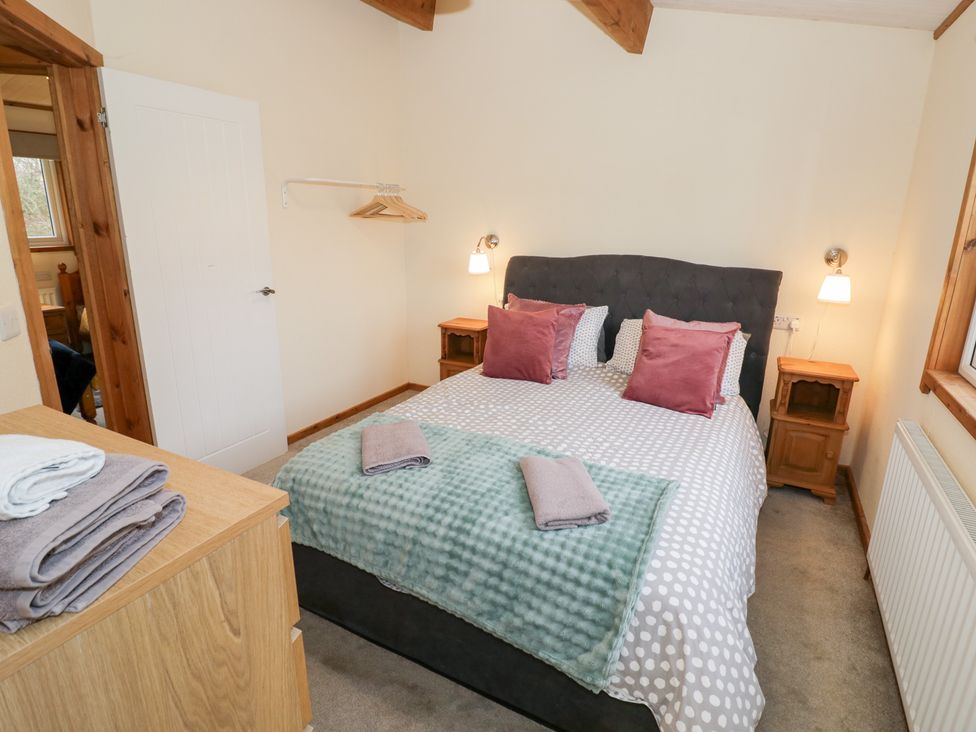 A bedroom with a bed and bedside tables at Birch Lodge in Rugeley
