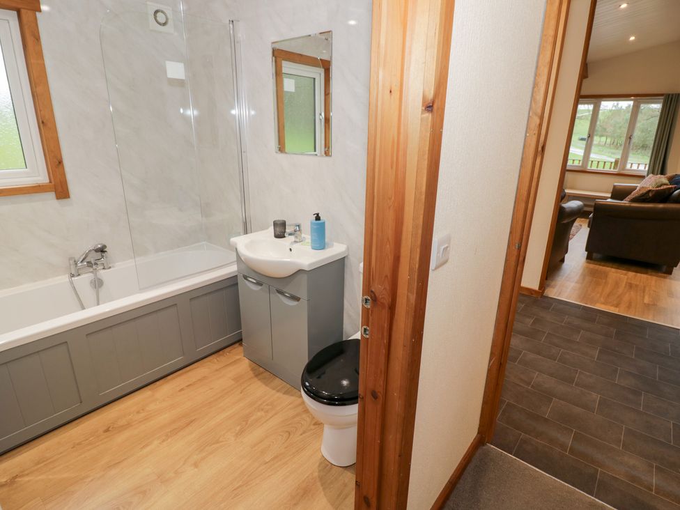 A bathroom with a bathtub and sink at Birch Lodge in Rugeley