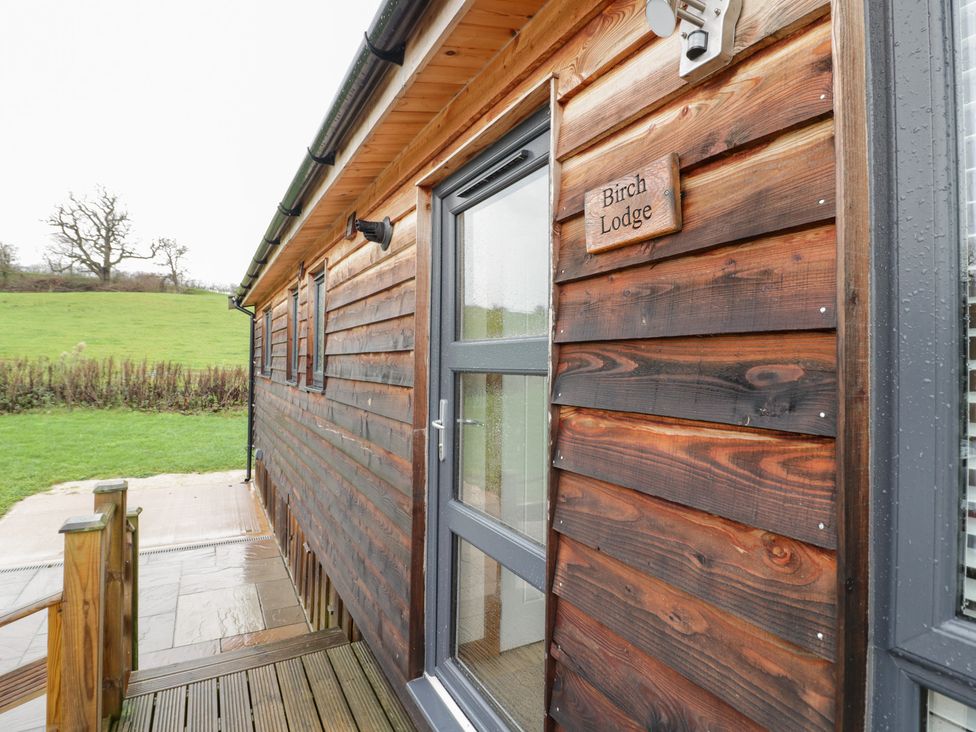 A wooden exterior of Birch Lodge with a sliding door in Rugeley
