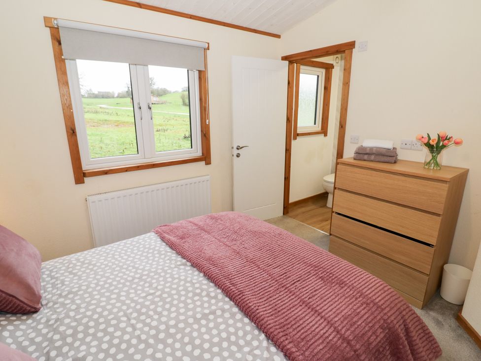 A bedroom with bed and dresser at Cedar Lodge in Rugeley
