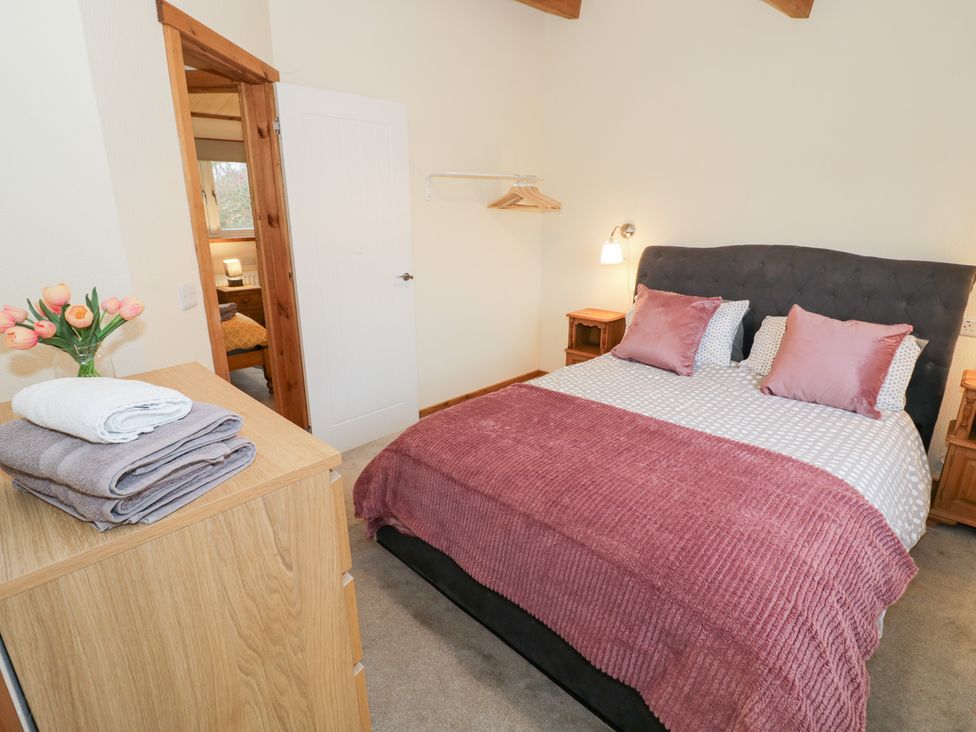 A bedroom with a bed and a dresser at Cedar Lodge in Rugeley