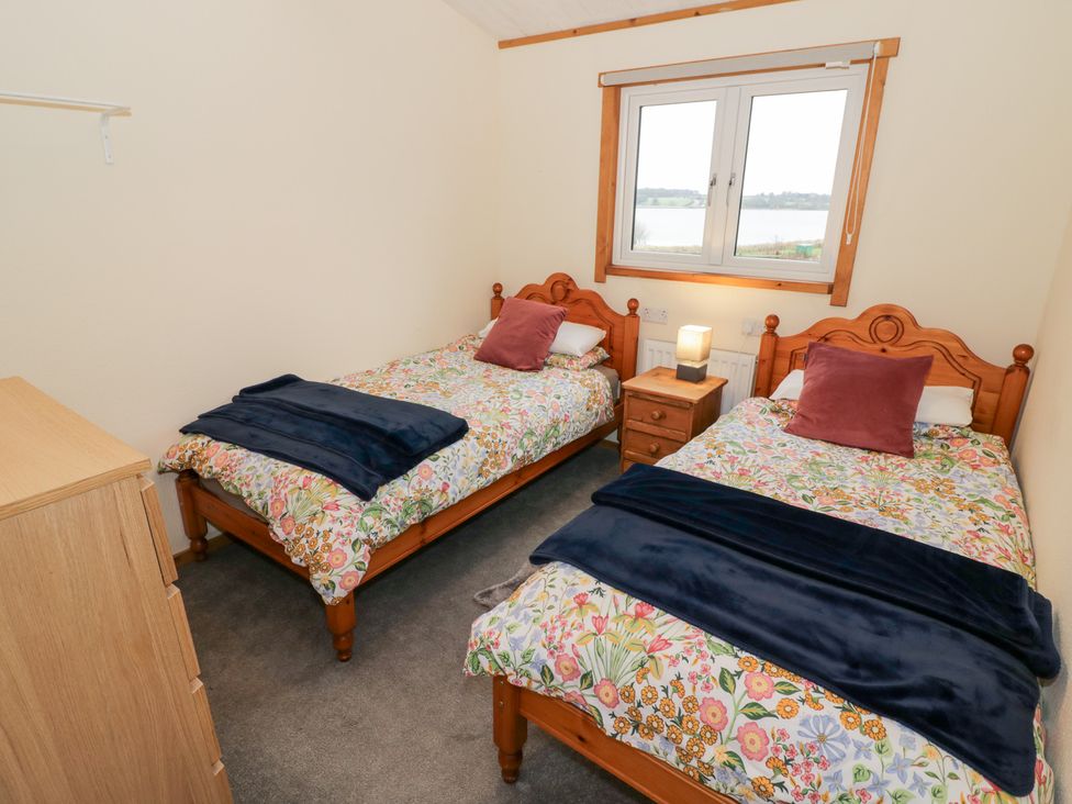 A bedroom with two single beds and a window at Cedar Lodge in Rugeley