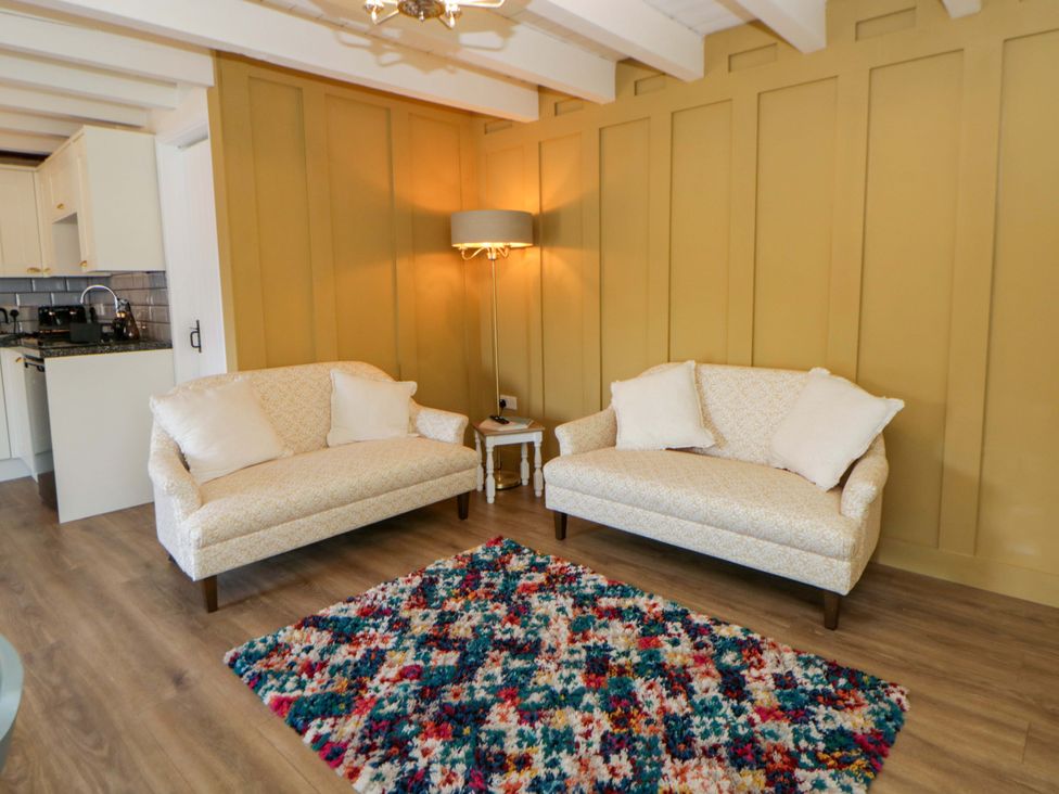 A living room with sofas and a lamp at Shearers in Llandysul