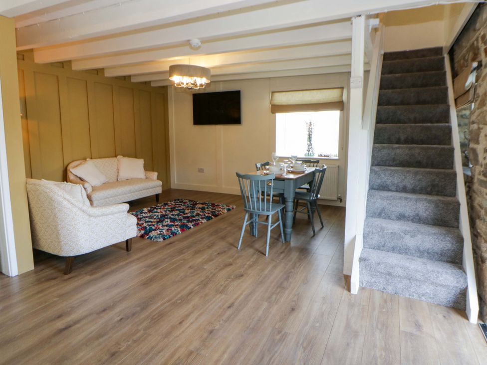 A living room with a sofa and dining area at Shearers in Llandysul