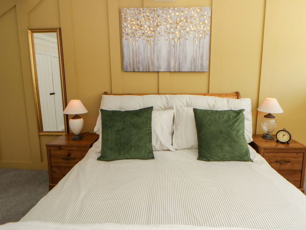 A bedroom with a bed and bedside tables at Shearers in Llandysul