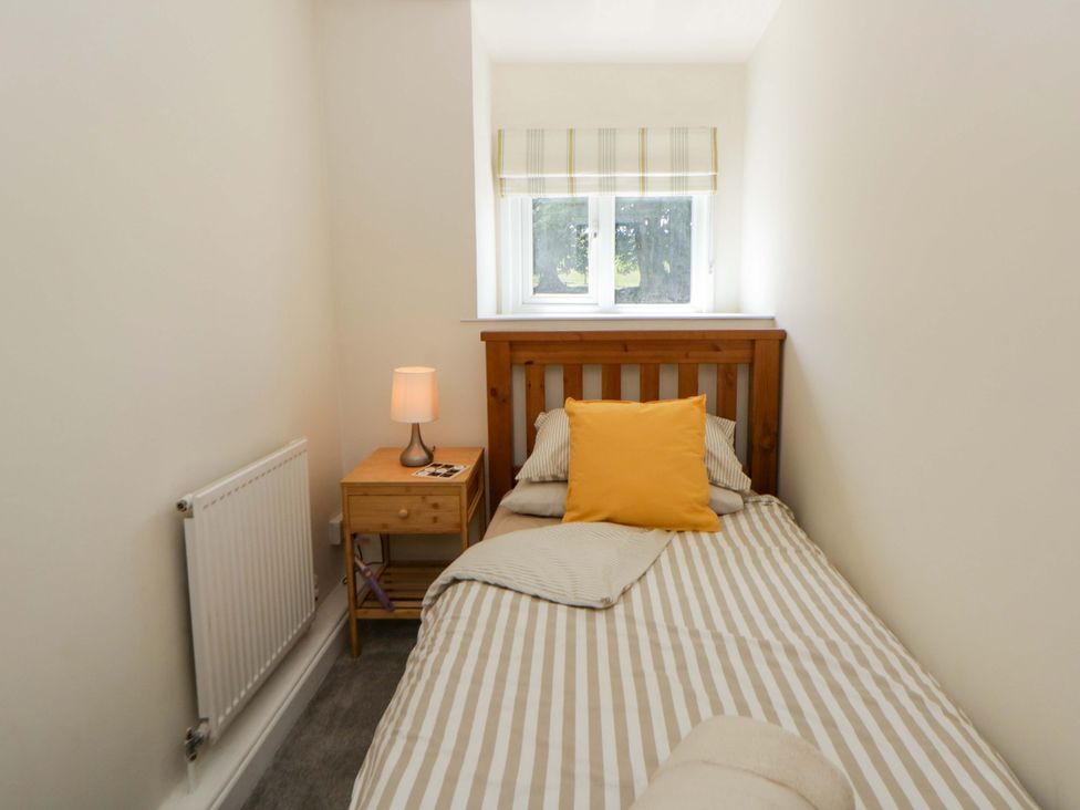 A bedroom with a single bed and a bedside table at Shearers in Llandysul