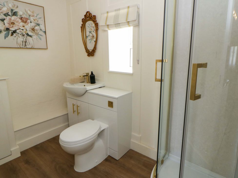 A bathroom with a sink, toilet, and shower at Shearers in Llandysul