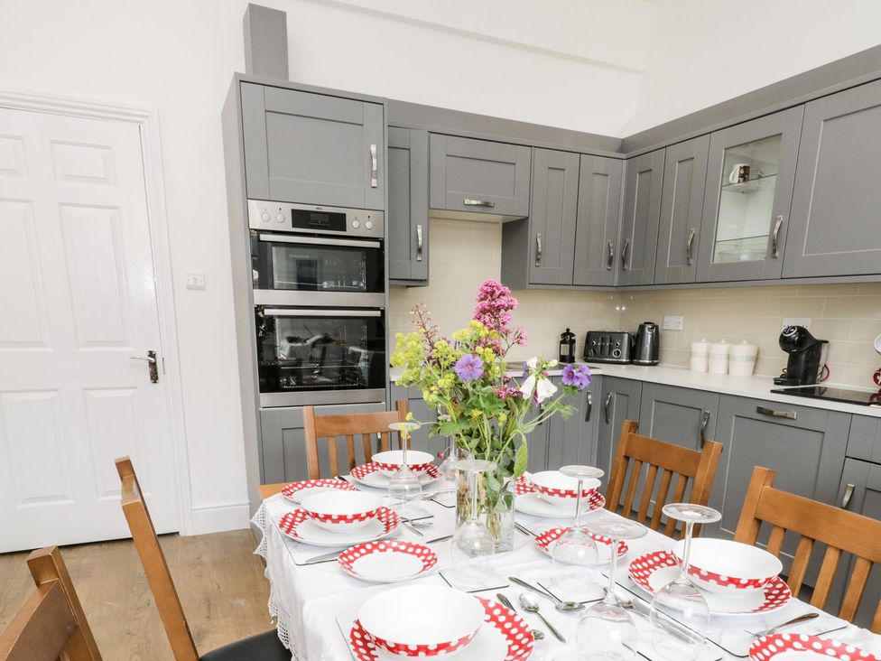 A kitchen with a dining table and flower vase at The Kesi Residence in Loftus