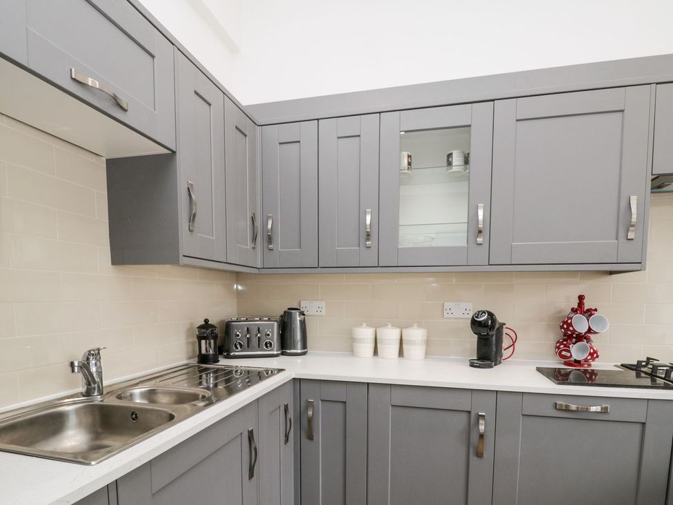 A kitchen with grey cabinets and appliances at The Kesi Residence in Loftus