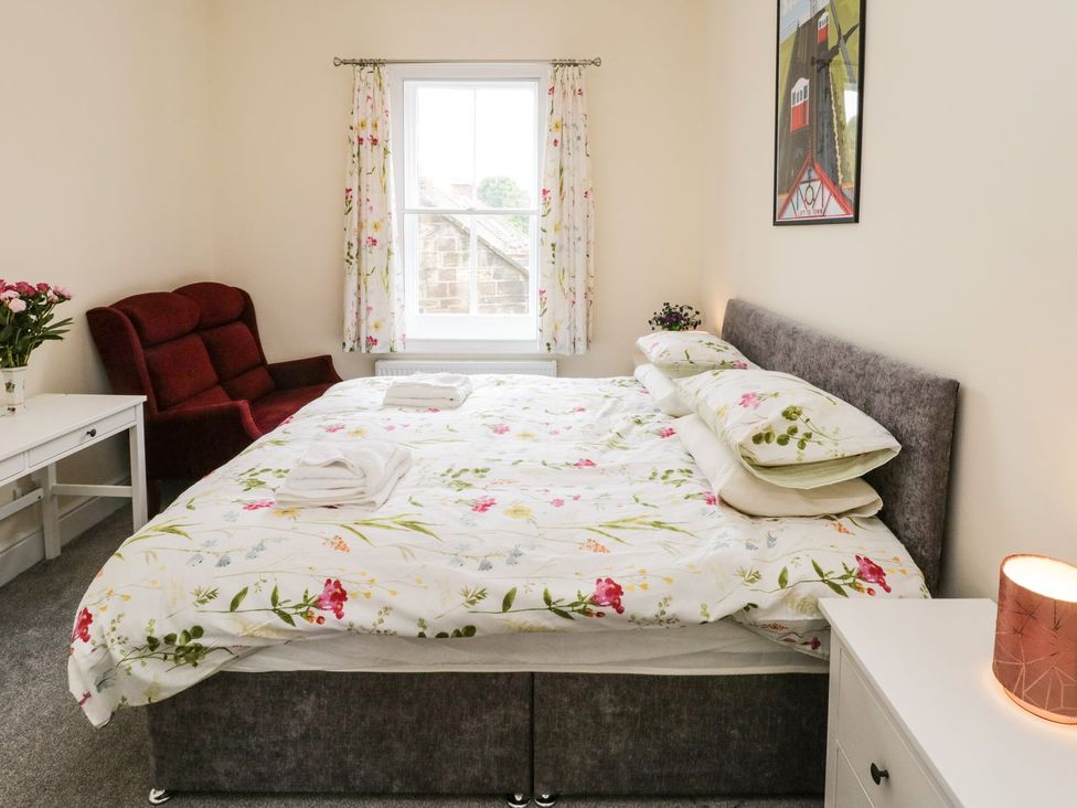 A bedroom with a bed and a chair at The Kesi Residence in Loftus