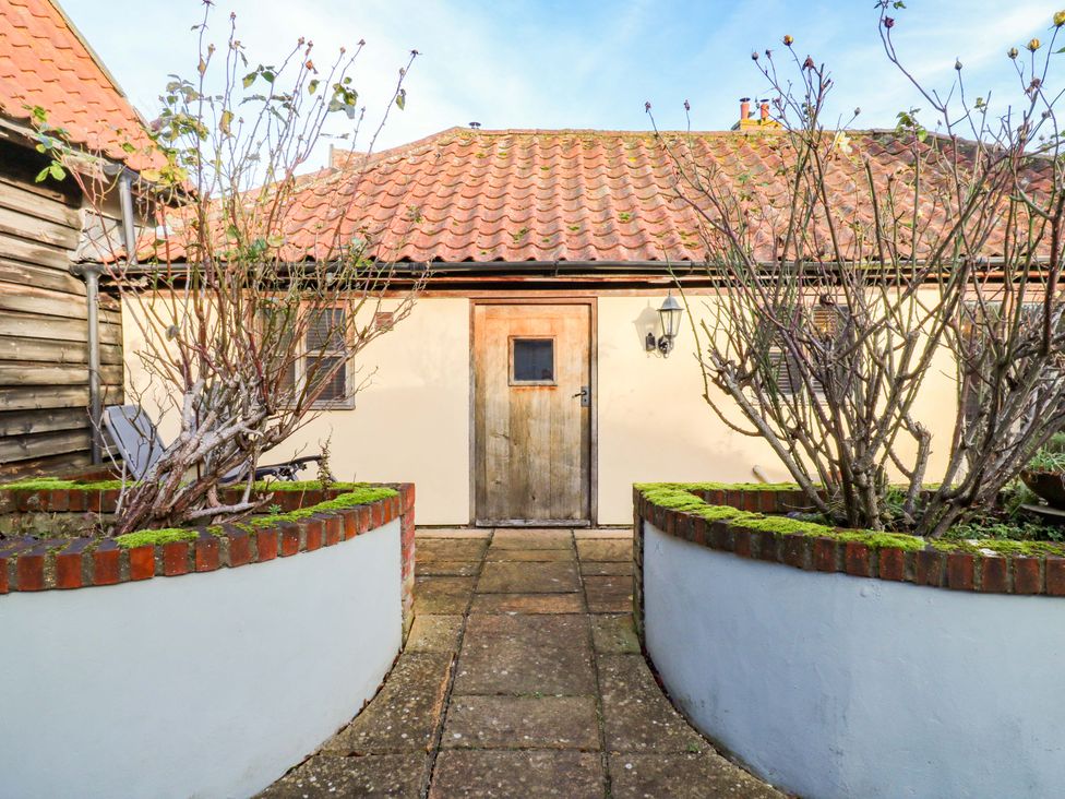 An outdoor area with a door and plants at The Old Cow Shed 