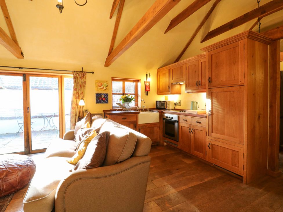 A kitchen with a sofa and appliances at The Old Cow Shed in 