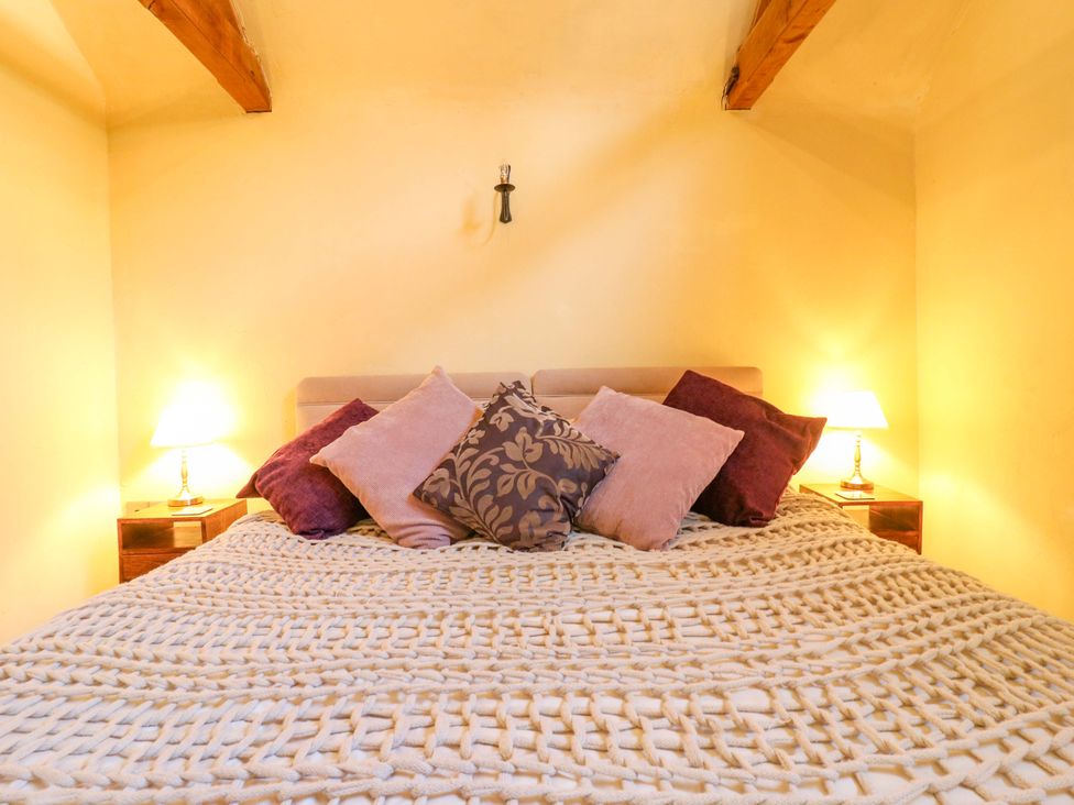 A bedroom with a bed and pillows at The Old Cow Shed in 