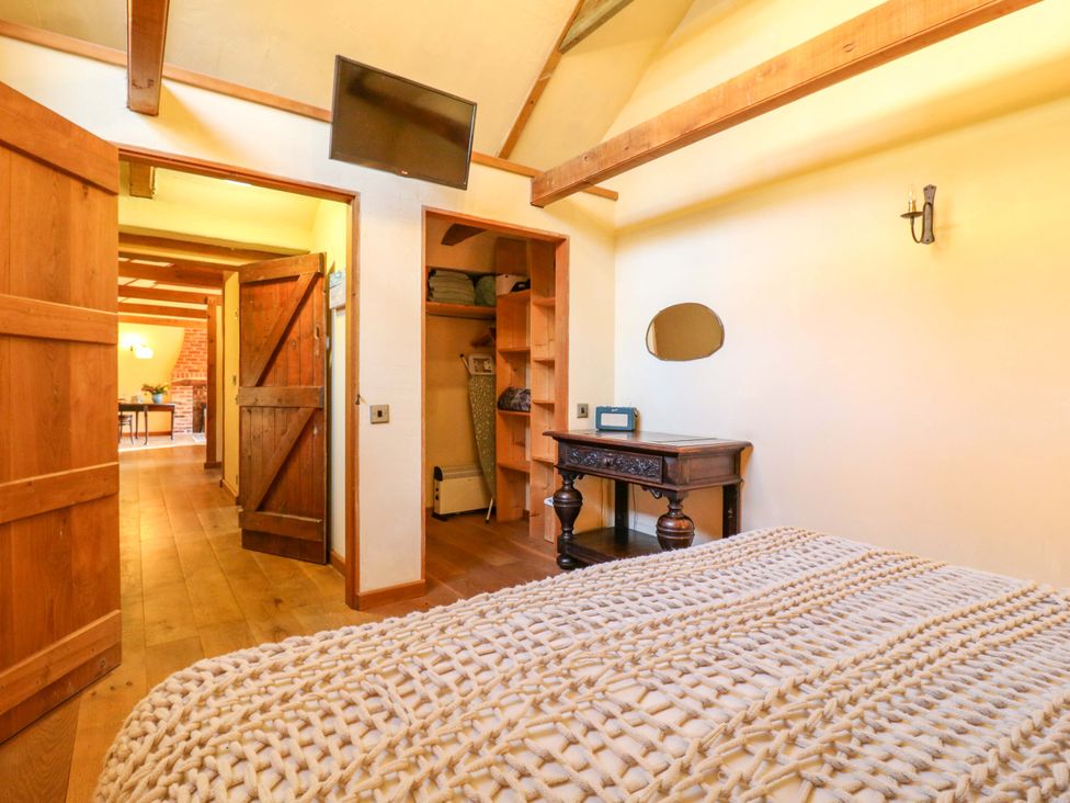 A bedroom with a bed and a television at The Old Cow Shed in 
