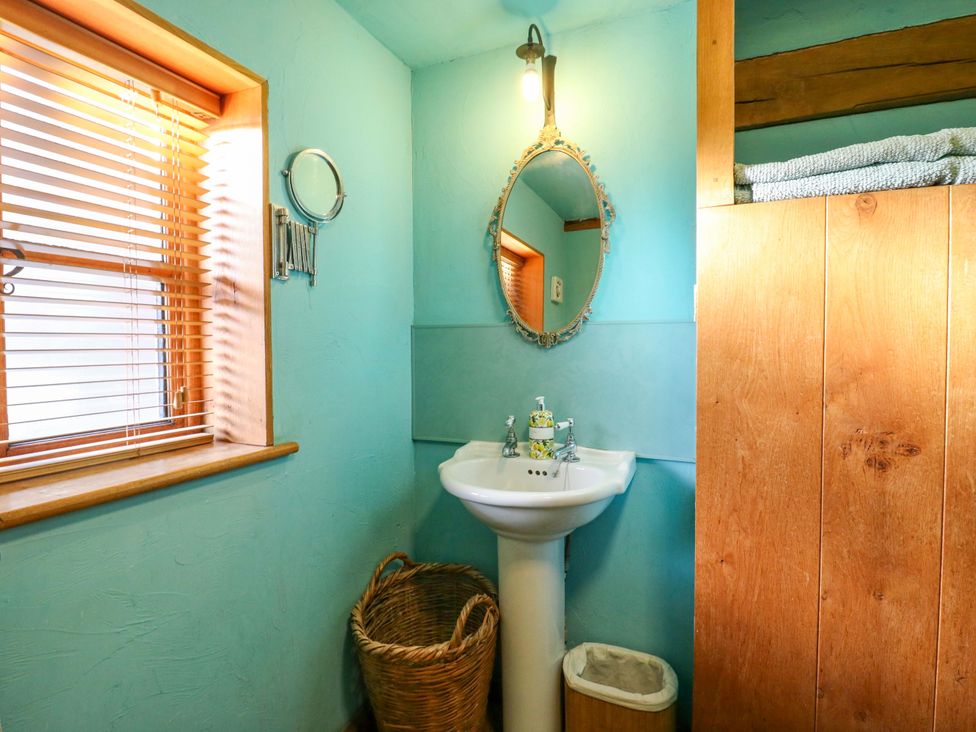 A bathroom with a sink and mirror at The Old Cow Shed in 