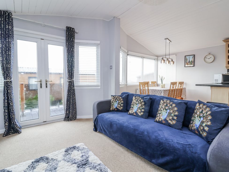 A living room with a sofa and dining area at Ocean View in Ilfracombe