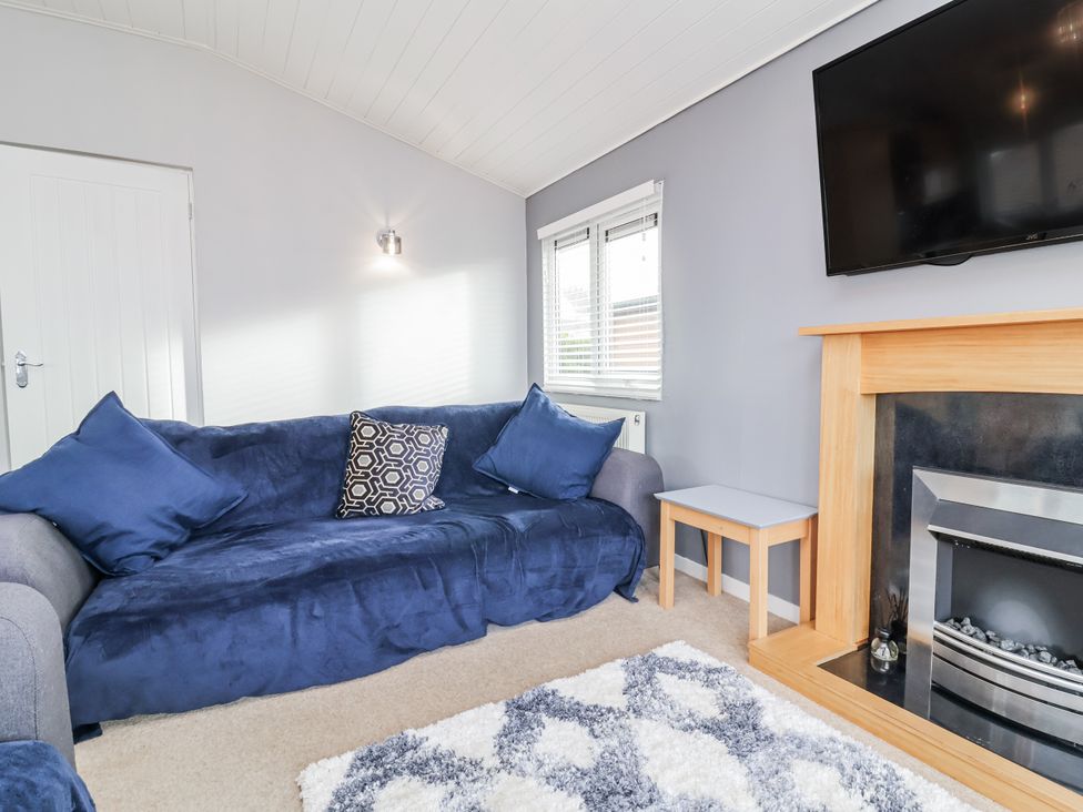 A living room with a sofa, coffee table, television and fireplace at Ocean View in Ilfracombe