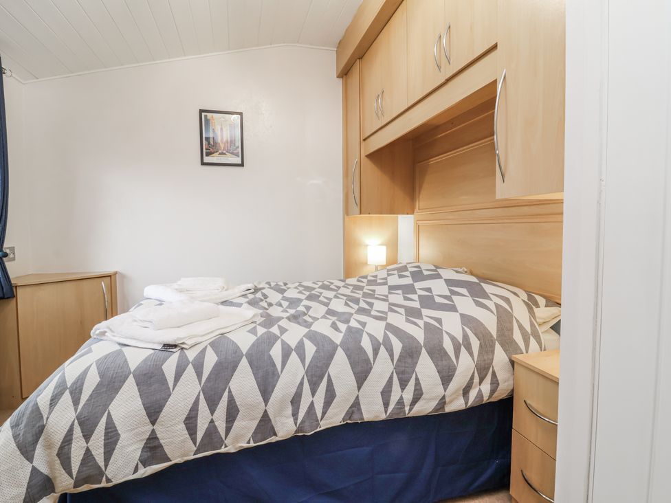 A bedroom with a bed and wardrobe at Ocean View in Ilfracombe