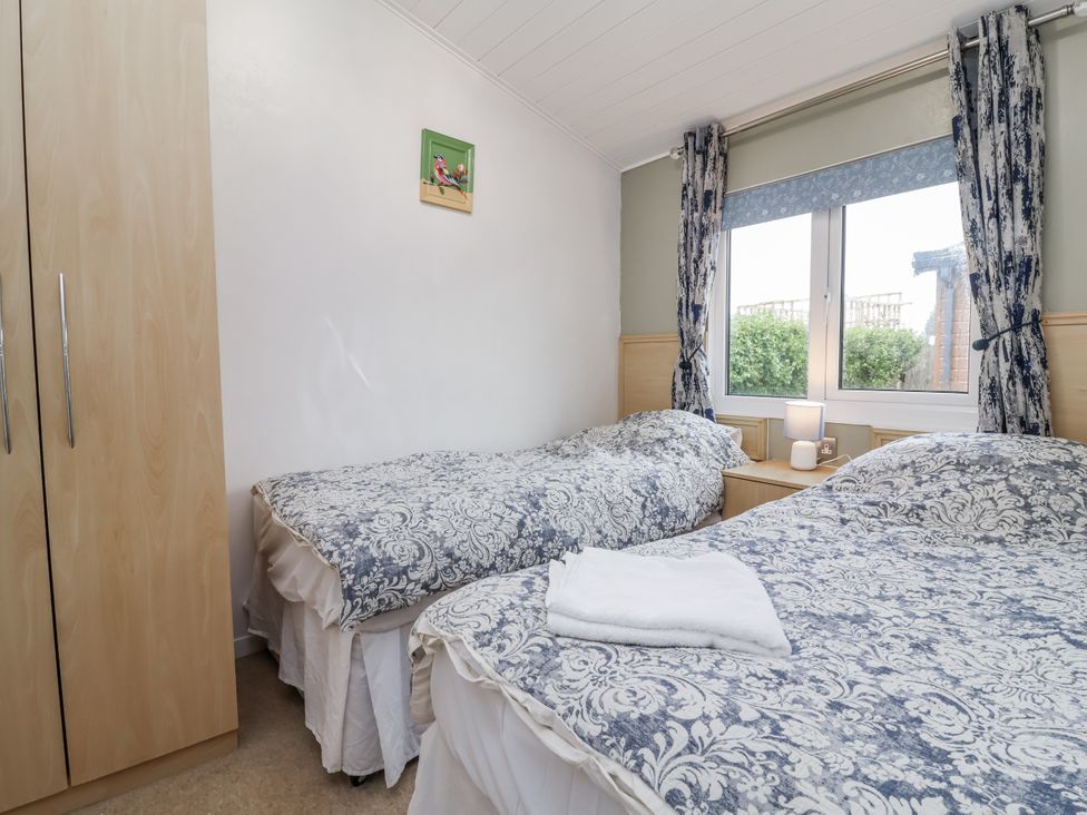 A bedroom with two beds and a wardrobe at Ocean View in Ilfracombe