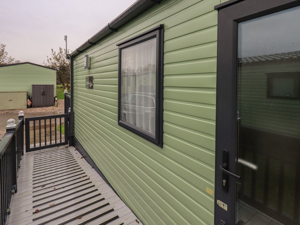 A caravan exterior with a deck and railing at Caravan