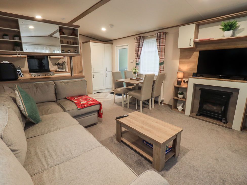 A living room with a sofa coffee table and television at Caravan