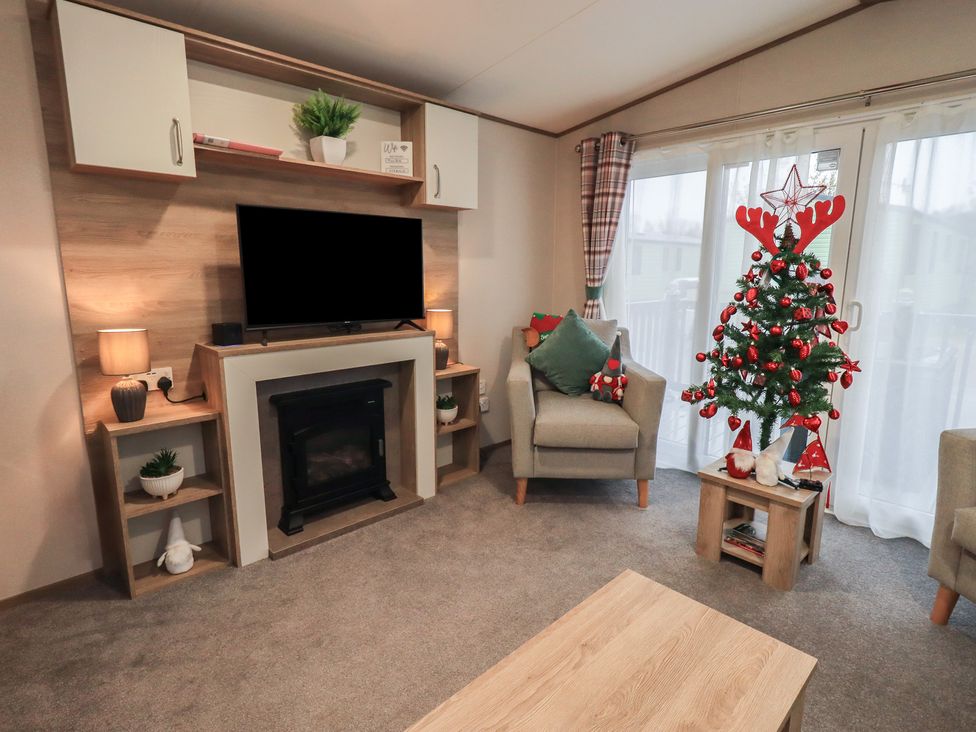 A living room with a television and a Christmas tree at Caravan