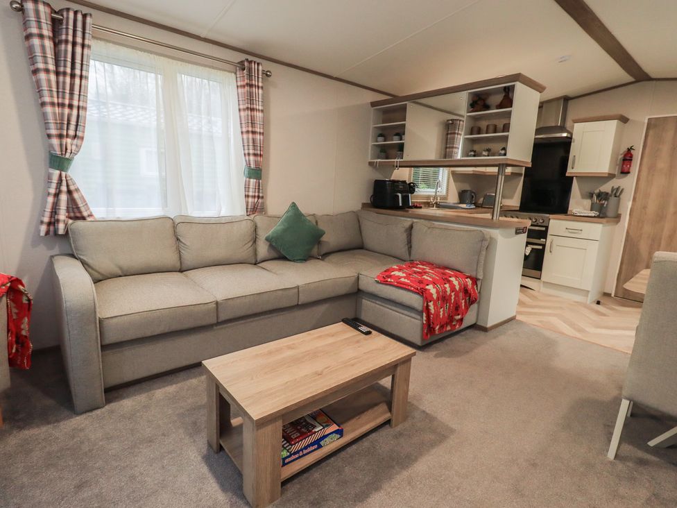 A living room with a sofa and kitchenette at Caravan