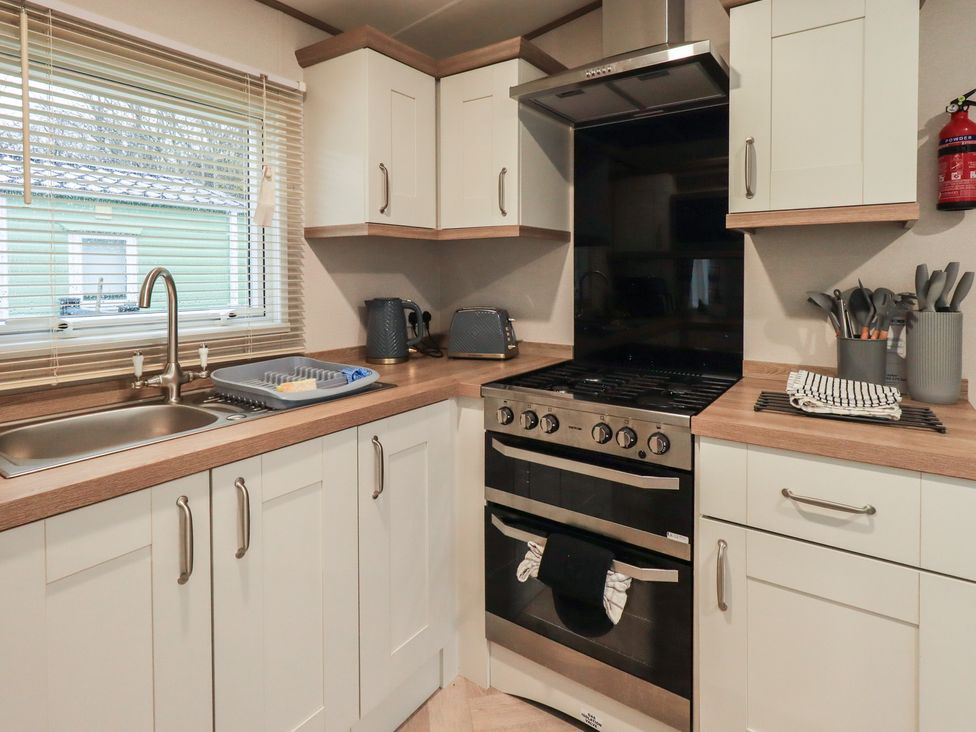 A kitchen with cabinets and appliances at Caravan