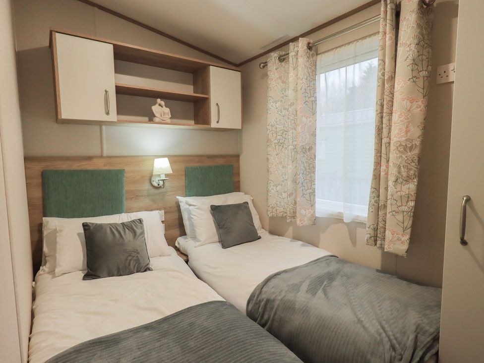 A bedroom with two beds and a shelf at Caravan