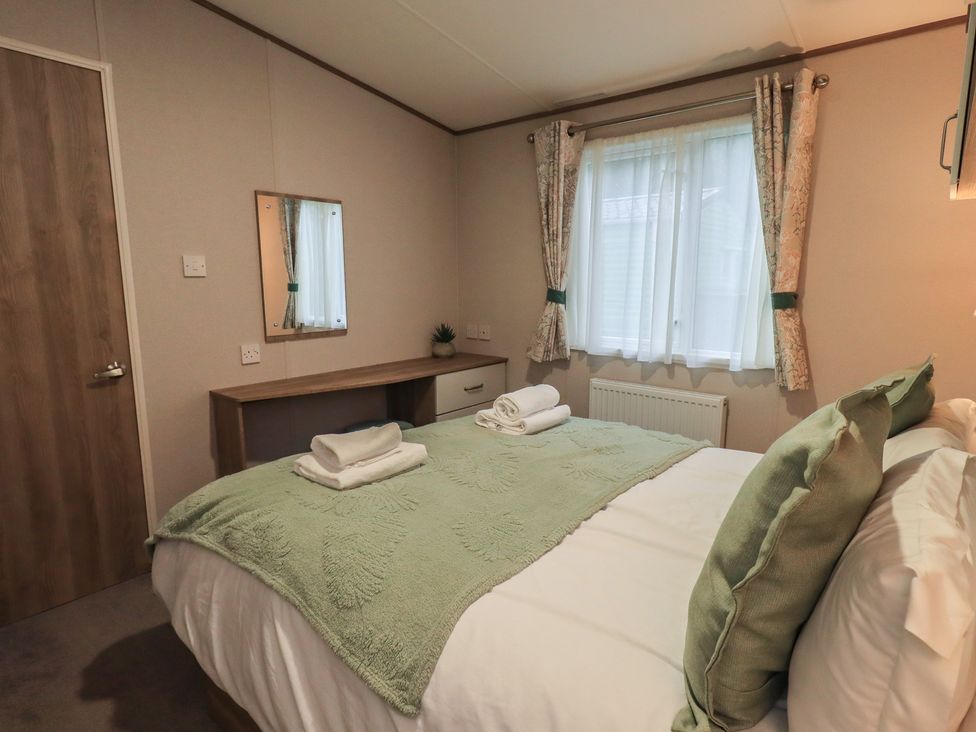 A bedroom with a bed and desk at Caravan 