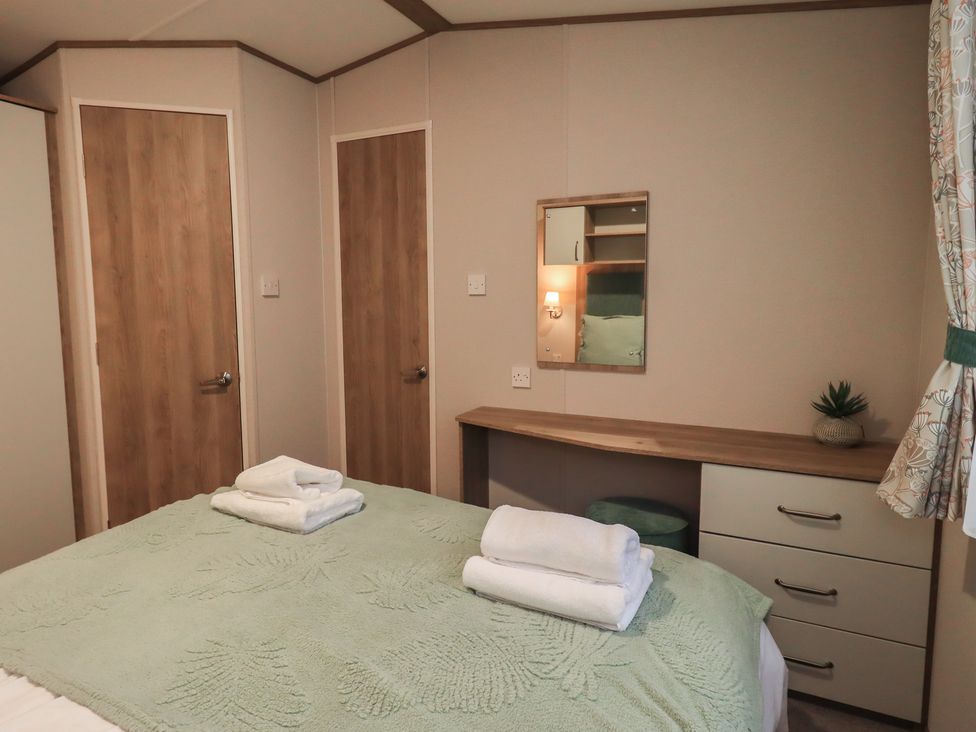 A bedroom with a bed and bedside furniture at Caravan