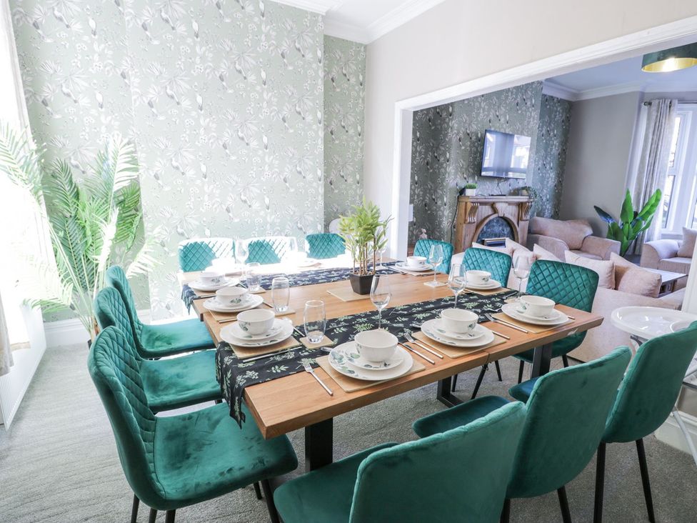 A dining room with a table set for meals at Canning Lodge in Colwyn Bay