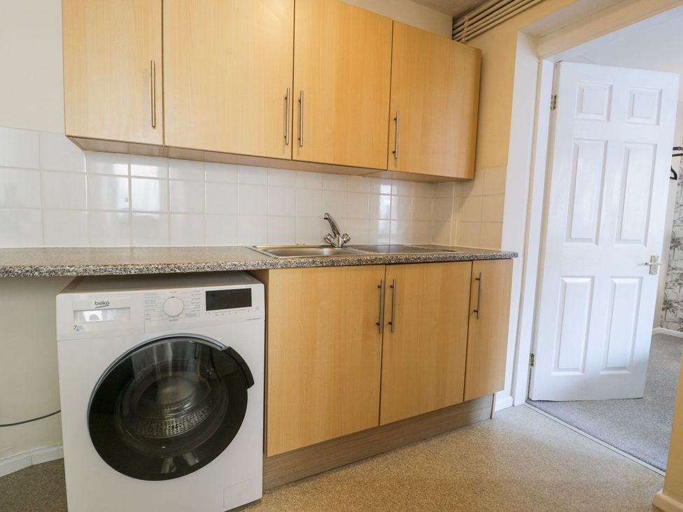 A kitchen with a washing machine and a sink at Canning Lodge in Colwyn Bay