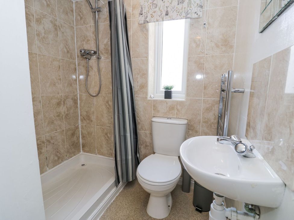 A bathroom with a shower, toilet, and sink at Canning Lodge in Colwyn Bay