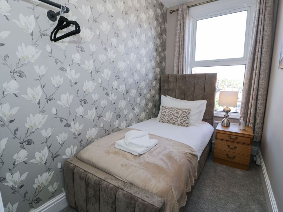 A bedroom with a bed and bedside table at Canning Lodge in Colwyn Bay