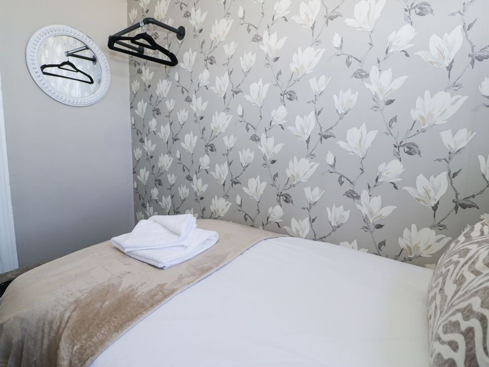 A bedroom with bed and towels at Canning Lodge in Colwyn Bay