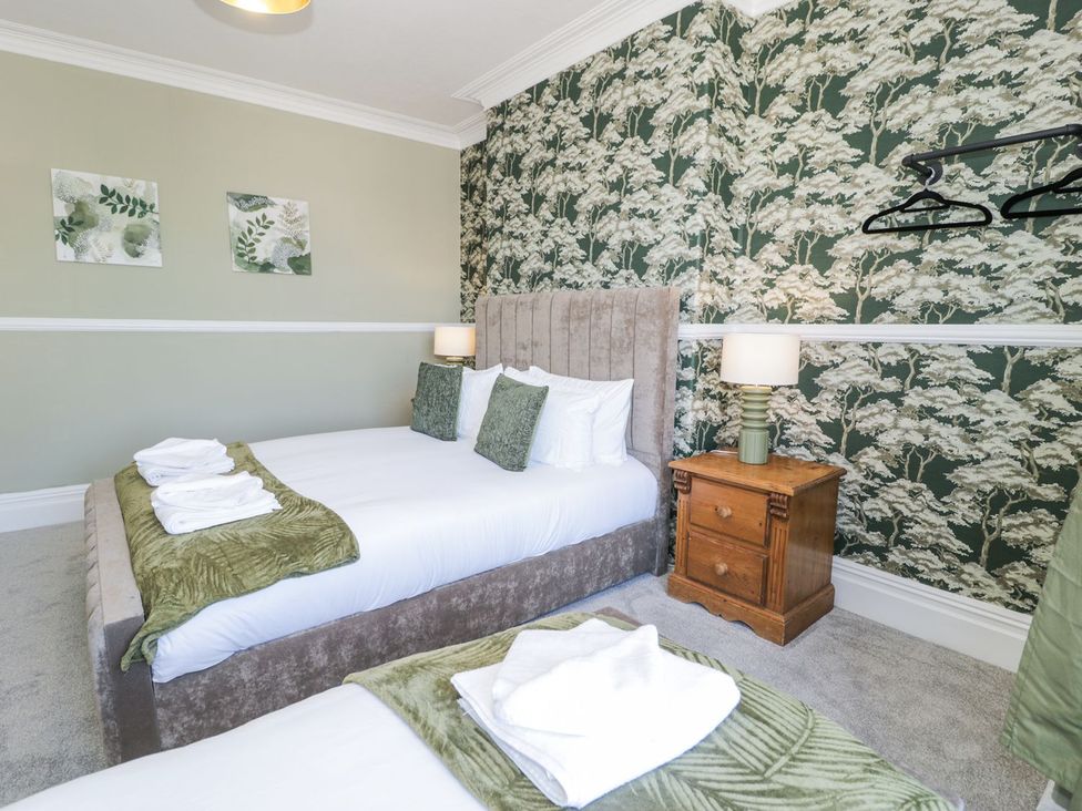 A bedroom with two beds and furniture at Canning Lodge in Colwyn Bay