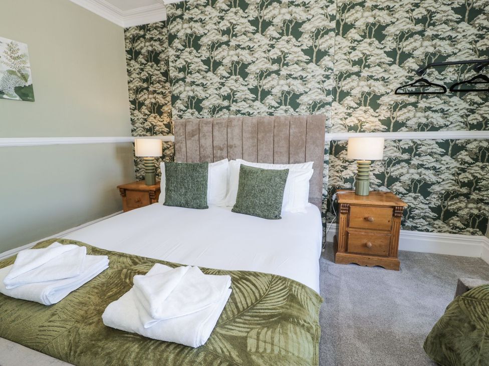 A bedroom with a bed and bedside tables at Canning Lodge in Colwyn Bay