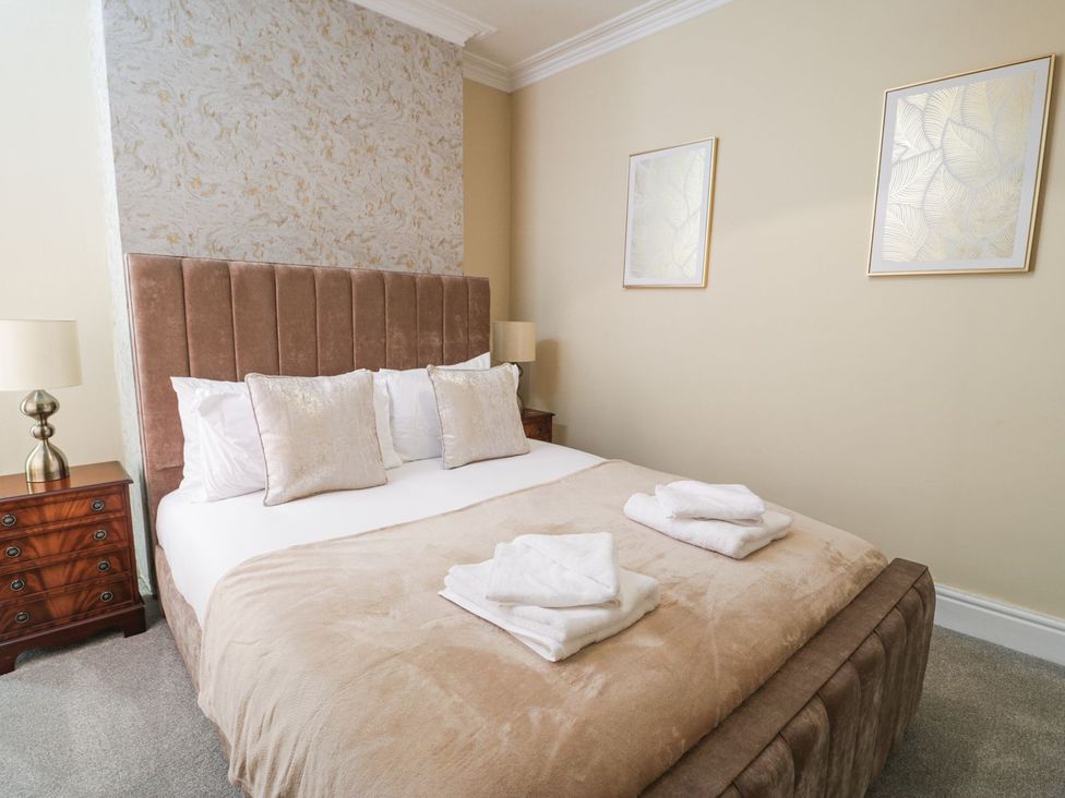 A bedroom with a bed and nightstands at Canning Lodge in Colwyn Bay
