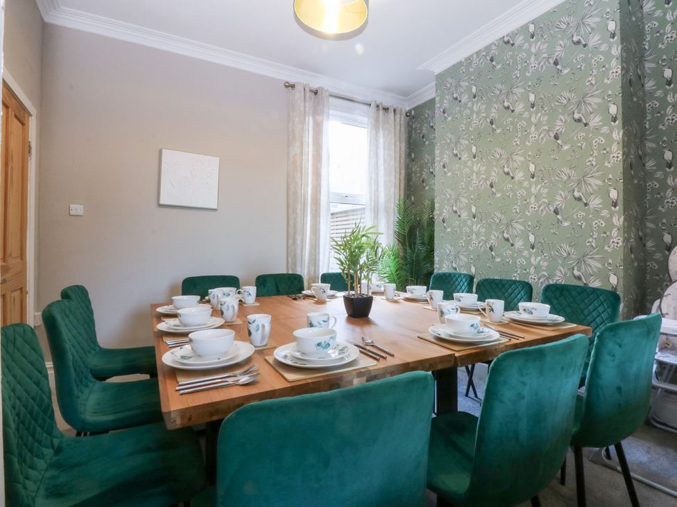 A dining room with a table set for meals at Canning Lodge Colwyn Bay