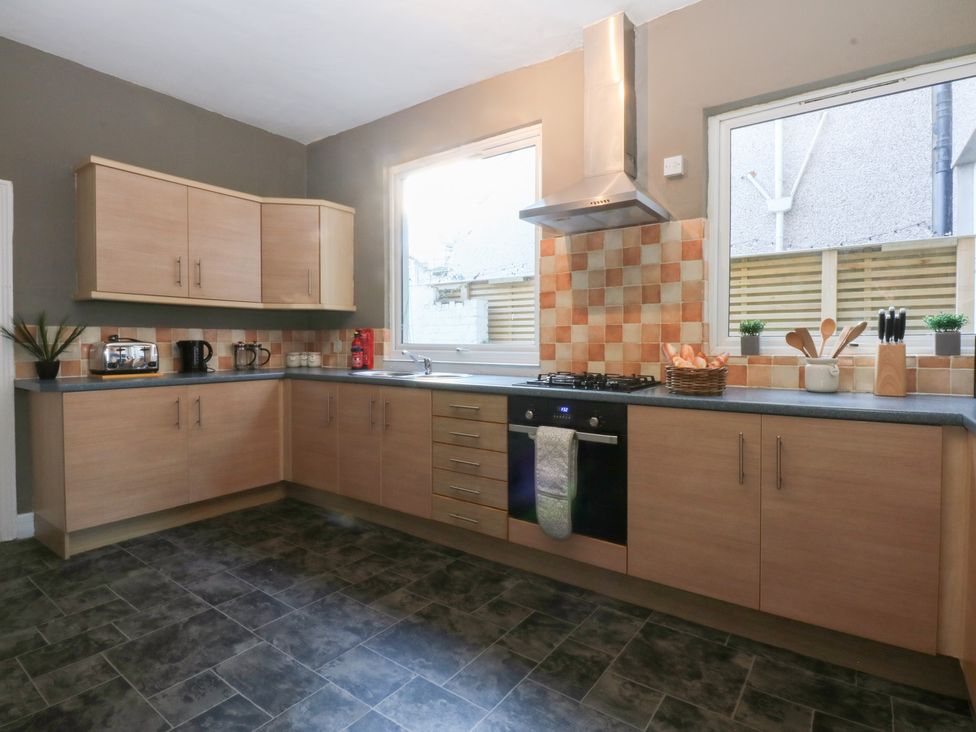 A kitchen with cabinets and appliances at Canning Lodge in Colwyn Bay