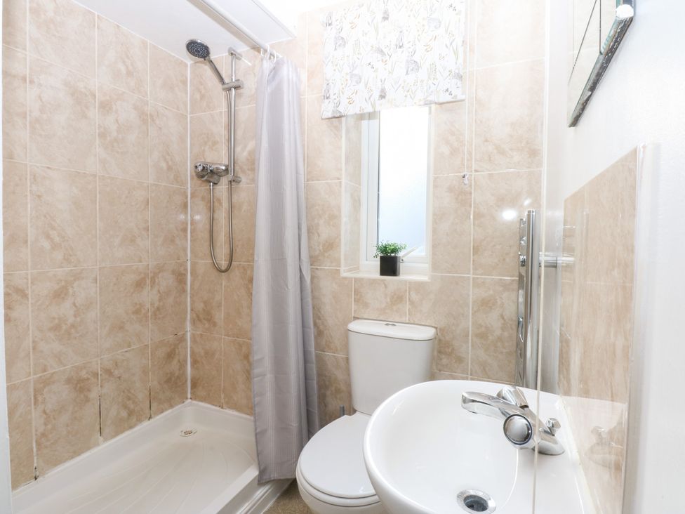 A bathroom featuring a shower, toilet, and sink at Canning Lodge in Colwyn Bay