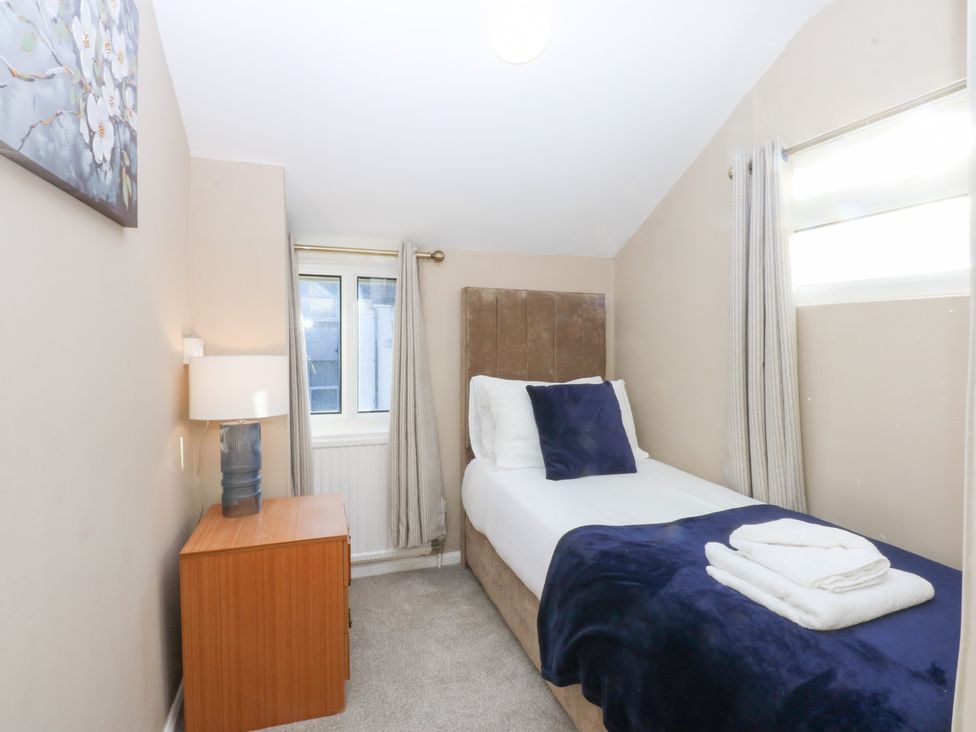 A bedroom with a single bed and nightstand at Canning Lodge in Colwyn Bay