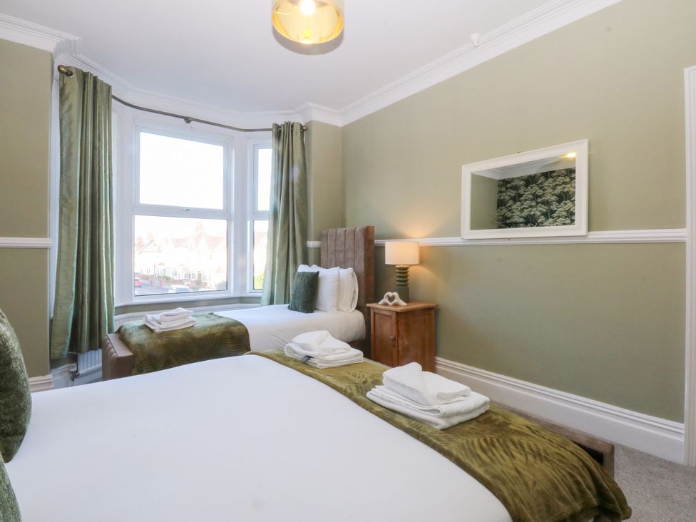 A bedroom with two beds and a window at Canning Lodge in Colwyn Bay