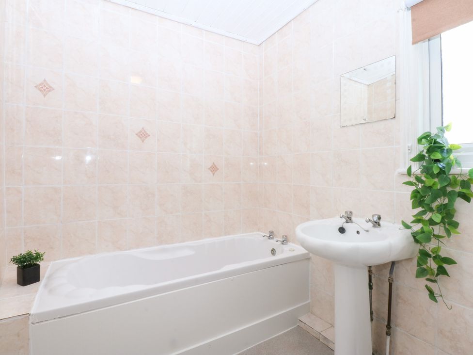 A bathroom with a bathtub and a sink at Canning Lodge in Colwyn Bay