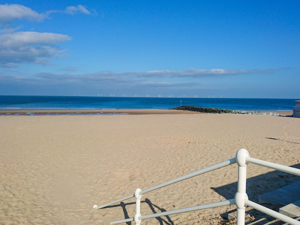 A beach with sand and ocean view at Canning Lodge in Colwyn Bay