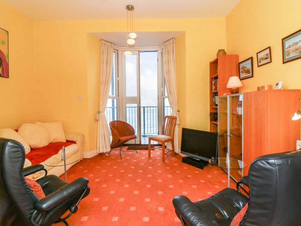 A living room with a sofa and two chairs at Val's Seaview in Ilfracombe