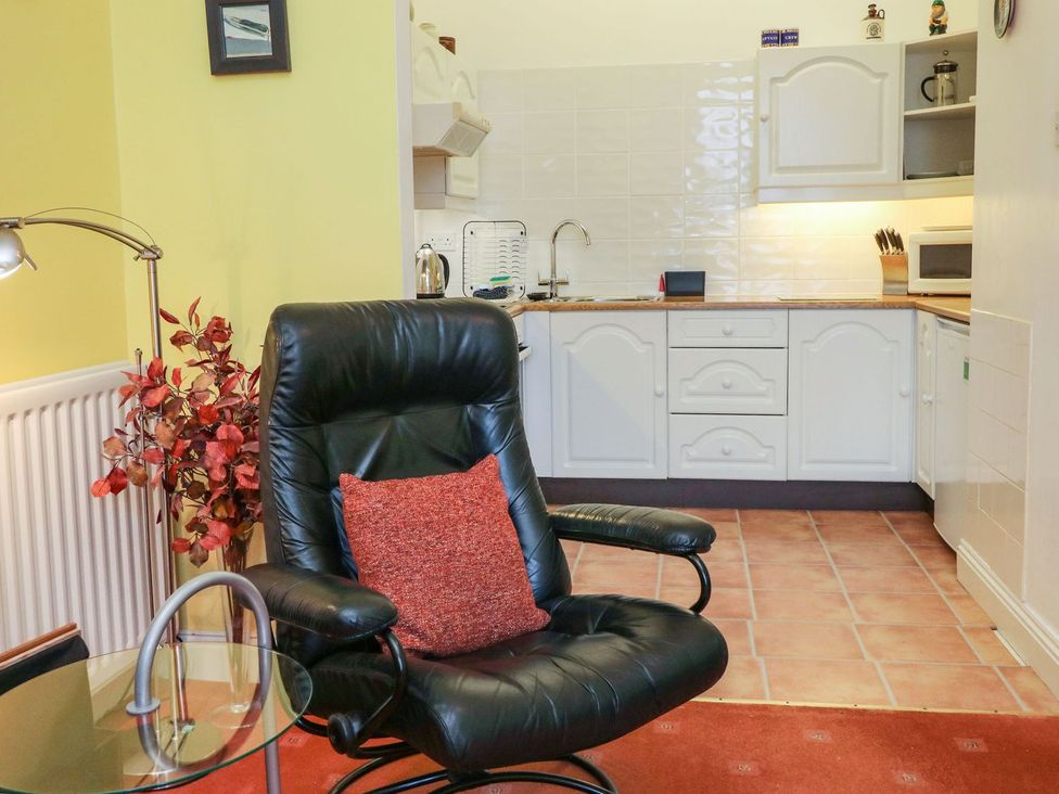 A kitchen with a recliner chair and coffee table at Val's Seaview in Ilfracombe