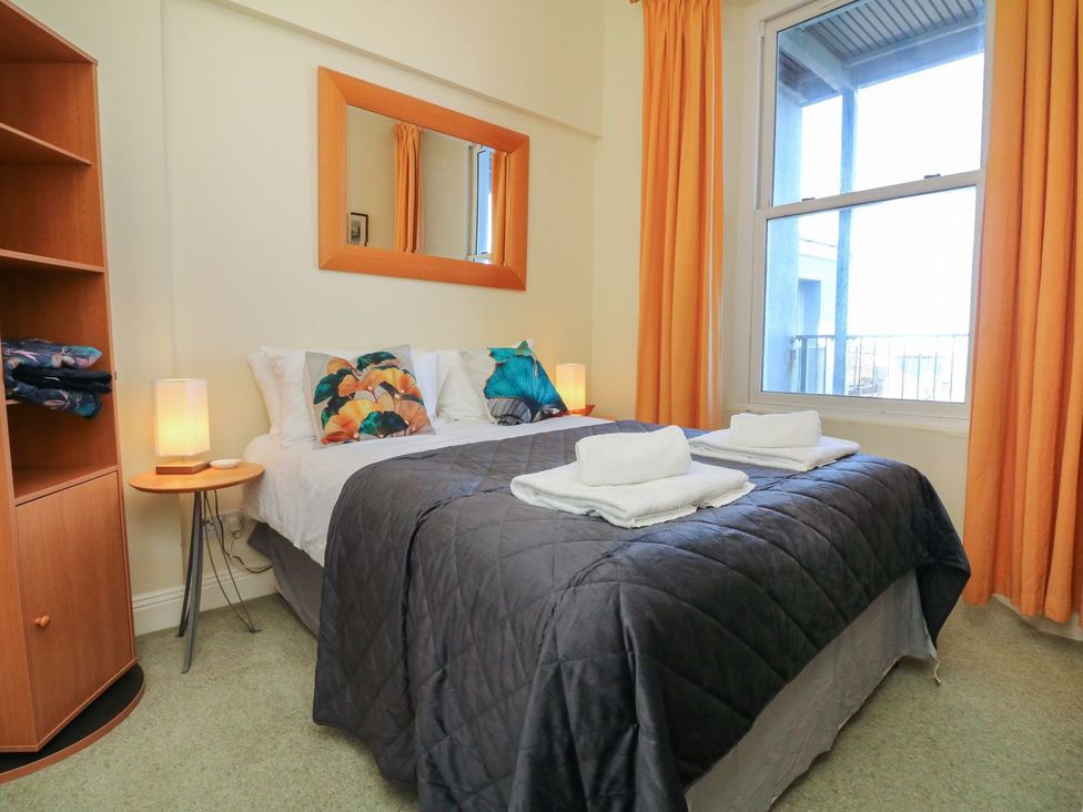 A bedroom with a bed and shelves at Val's Seaview in Ilfracombe