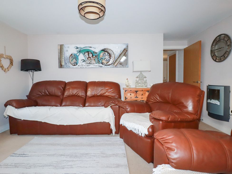 A living room with leather furniture and artwork at 18 Pagoda Drive St. Austell